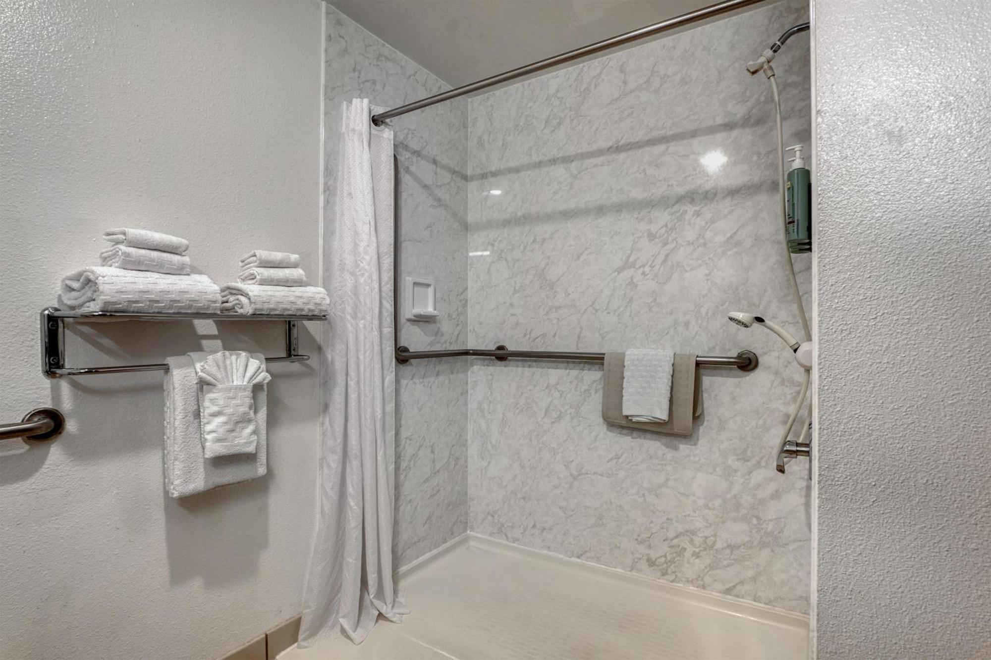 Habitación con ducha a ras de suelo adaptada para personas con discapacidad - Cama grande